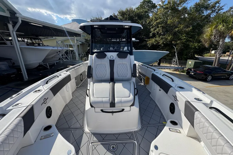 Slide: The Image of 2025 Fountain 32 NX boat with sleek seating and modern design in a marina setting. - 20