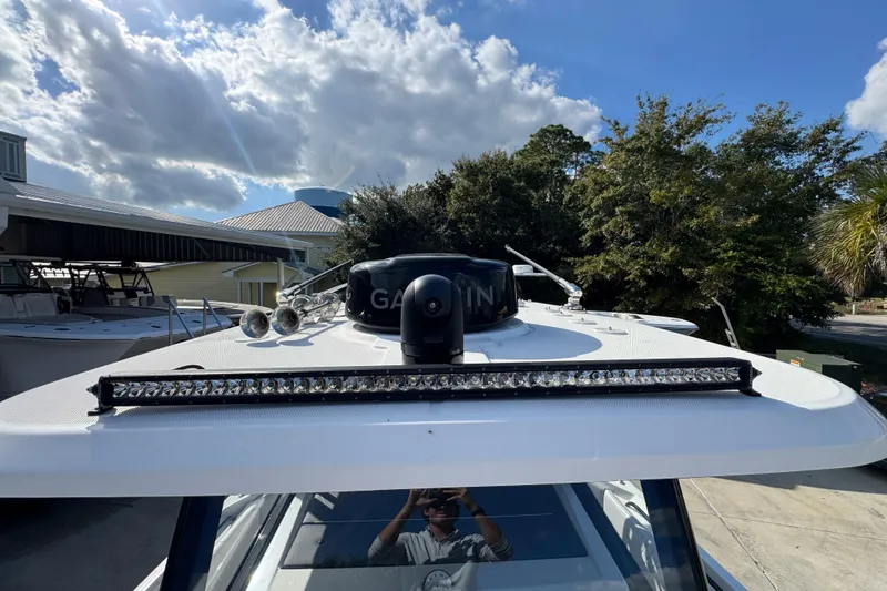 Slide: The Image of 2025 Fountain 32 NX boat with radar and light bar under a blue sky. - 21