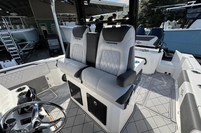 Slide: The Image of 2025 Fountain 32 NX boat interior with luxurious seating and modern steering wheel design. - 24