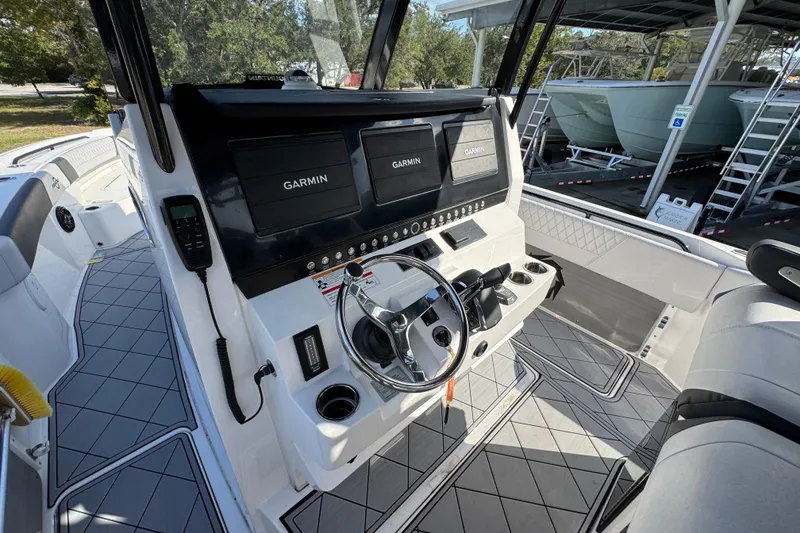 Slide: The Image of 2025 Fountain 32 NX boat cockpit with Garmin navigation displays and modern steering controls. - 27