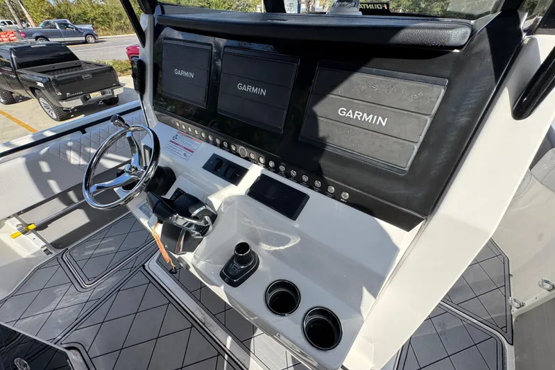 Slide: The Image of 2025 Fountain 32 NX boat dashboard with Garmin displays and steering wheel. - 30