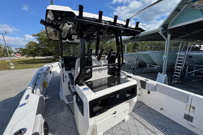 Slide: The Image of 2025 Fountain 32 NX boat interior with modern helm and seating, docked under clear skies. - 32