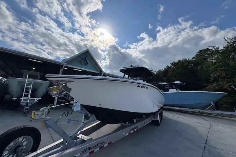 Slide: The Image of 2025 Fountain 32 NX boat on trailer under cloudy sky at marina. - 4