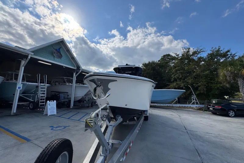 Slide: The Image of 2025 Fountain 32 NX boat on trailer under cloudy sky near storage facility. - 5