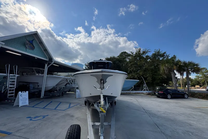 Slide: The Image of 2025 Fountain 32 NX boat on trailer under blue sky at dealership. - 6
