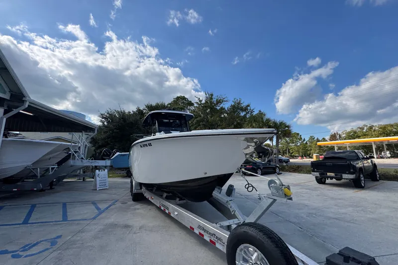 Slide: The Image of 2025 Fountain 32 NX boat on trailer under a partly cloudy sky. - 7