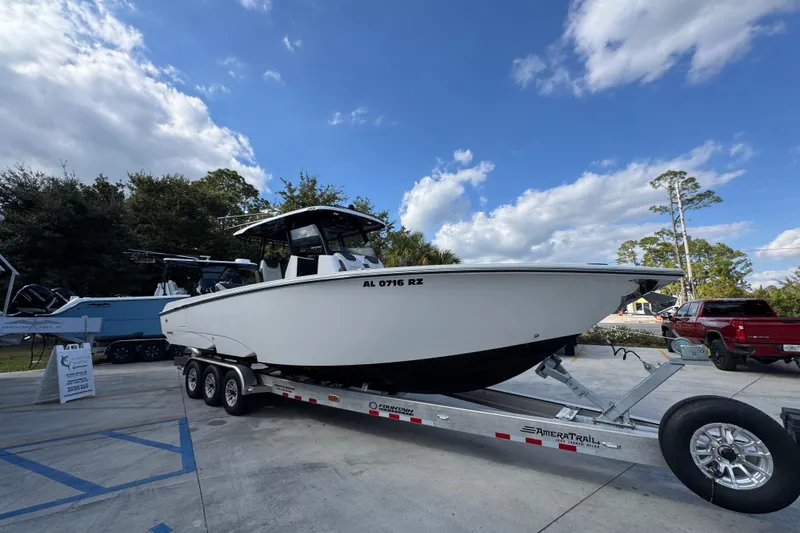 Slide: The Image of 2025 Fountain 32 NX boat on trailer under blue sky, parked outdoors. - 8