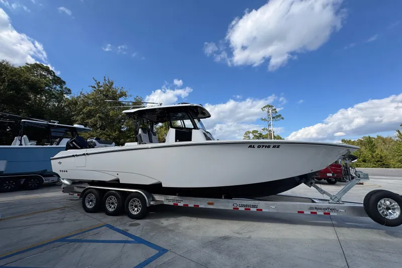 Slide: The Image of 2025 Fountain 32 NX boat on trailer under blue sky. - 9