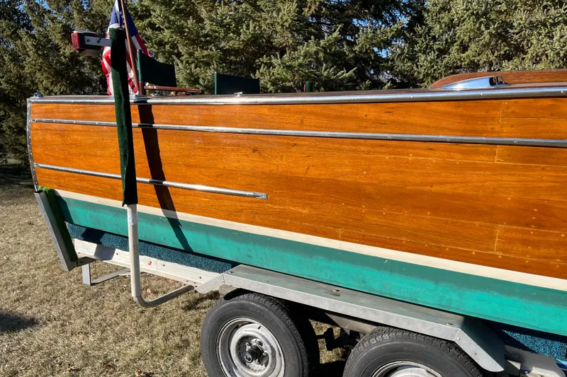 Slide: The Image of 1938 Chris-Craft 28 Sportsman boat on trailer, showcasing polished wooden exterior. - 7