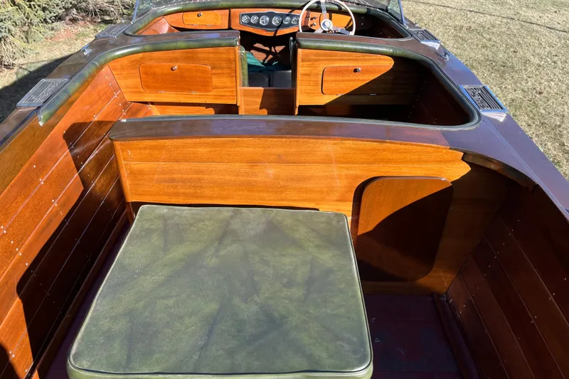 Slide: The Image of 1938 Chris-Craft 28 Sportsman boat interior with polished wood and green upholstery. - 14