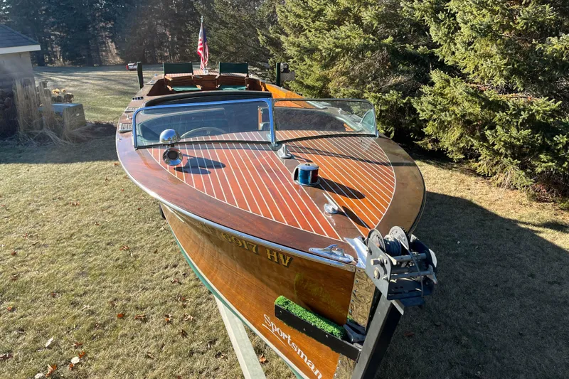 Slide: The Image of 1938 Chris-Craft 28 Sportsman wooden boat on display in a grassy area. - 3