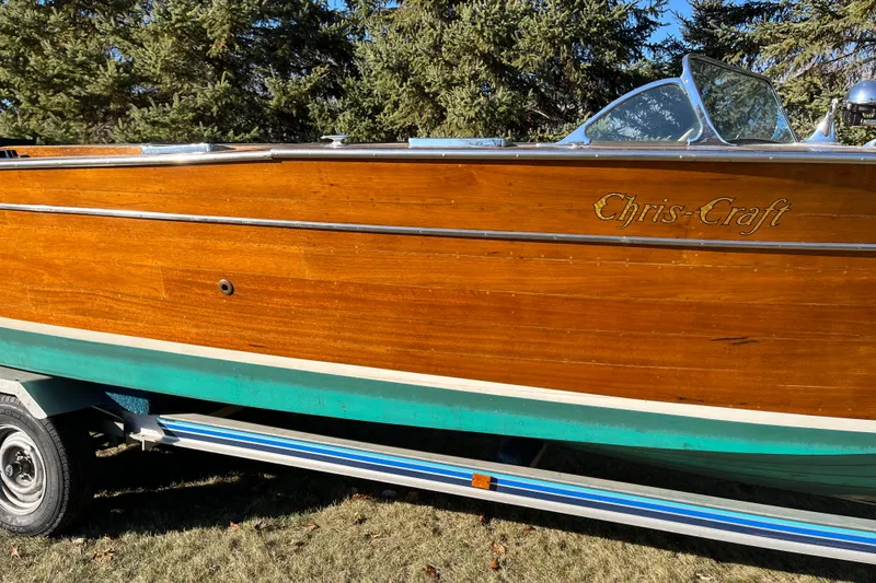 Slide: The Image of 1938 Chris-Craft 28 Sportsman wooden boat on trailer, surrounded by trees. - 8