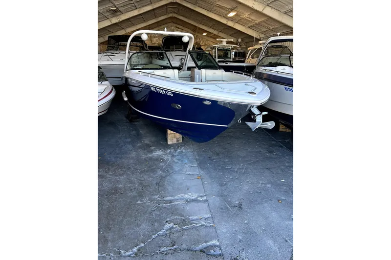 Slide: The Image of 2019 Regal 2800 Bowrider boat in storage, blue hull, indoor facility. - 0