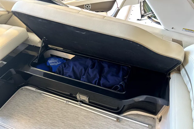 Slide: The Image of Open storage compartment in 2019 Regal 2800 Bowrider boat with blue bag inside. - 21