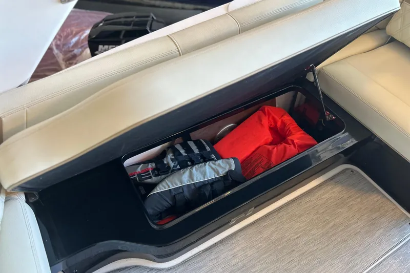 Slide: The Image of 2019 Regal 2800 Bowrider storage compartment with life jackets and safety gear. - 27