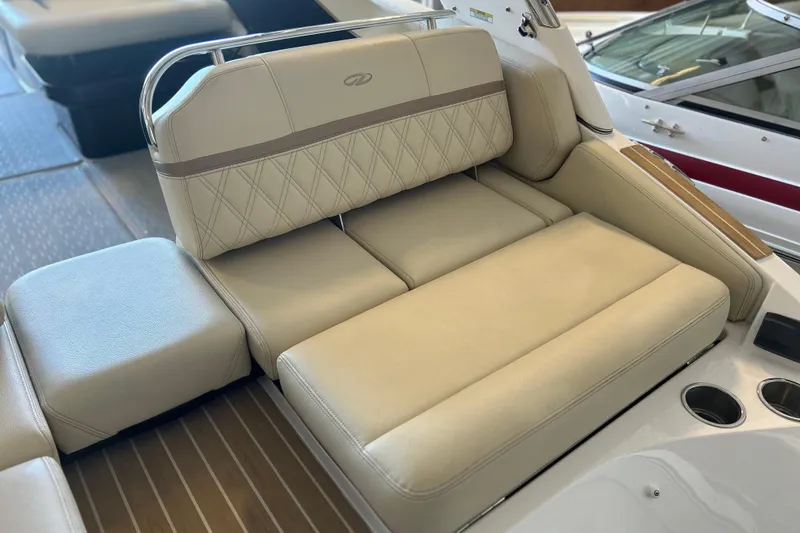 Slide: The Image of Luxurious seating on 2019 Regal 2800 Bowrider boat, featuring beige upholstery and cup holders. - 28