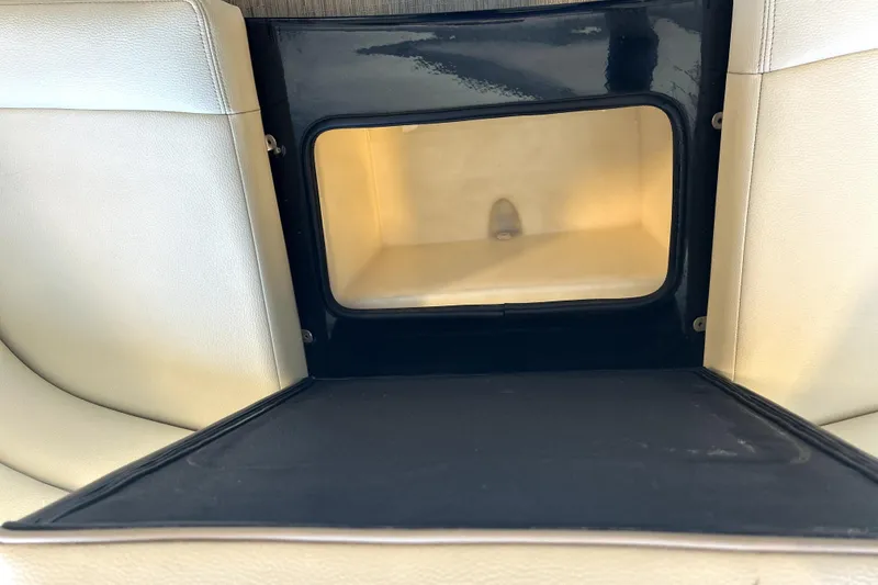 Slide: The Image of 2019 Regal 2800 Bowrider storage compartment with beige interior and black trim. - 7