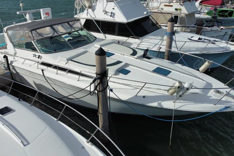 Slide: The Image of 1990 Sea Ray 420 Sundancer docked among other boats in a marina. - 14