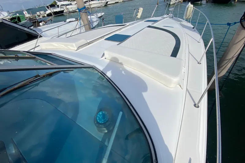 Slide: The Image of 1990 Sea Ray 420 Sundancer yacht docked, showcasing sleek deck design and marina setting. - 17