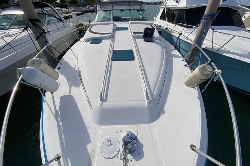 Slide: The Image of 1990 Sea Ray 420 Sundancer yacht docked, showcasing spacious deck and sleek design. - 21