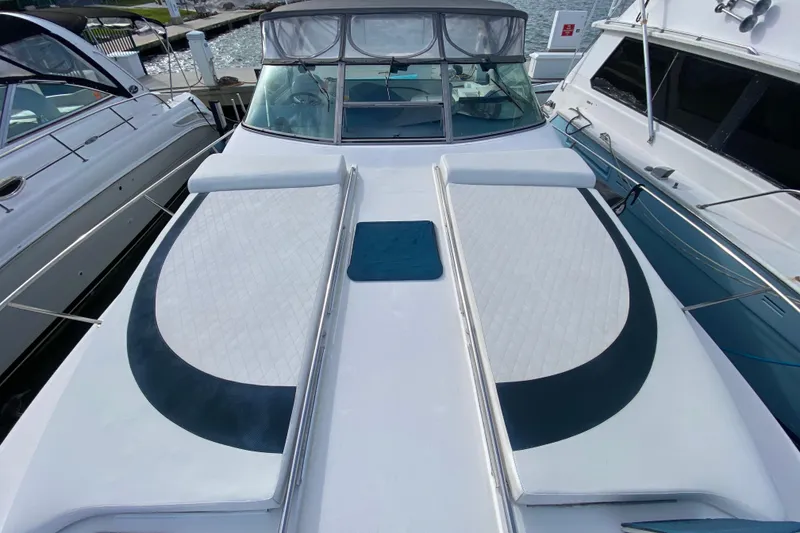 Slide: The Image of 1990 Sea Ray 420 Sundancer yacht with cushioned deck, docked at marina. - 22