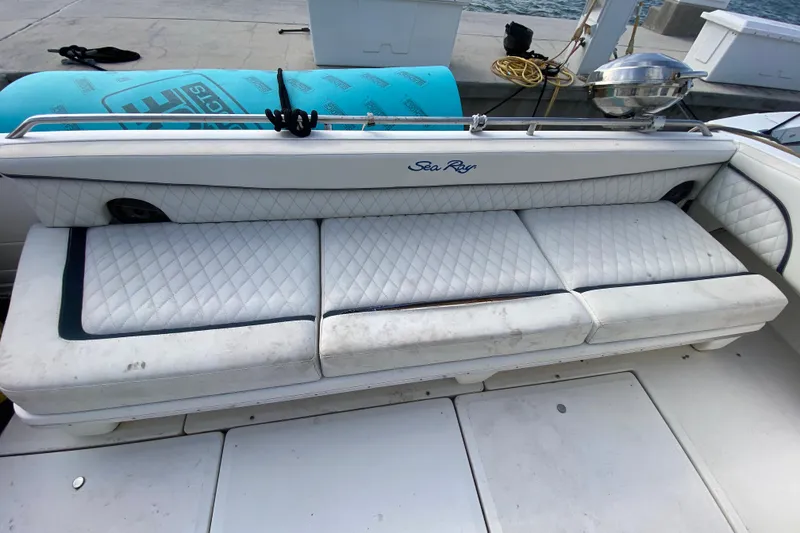 Slide: The Image of White leather seating on a 1990 Sea Ray 420 Sundancer boat, docked by the water. - 27