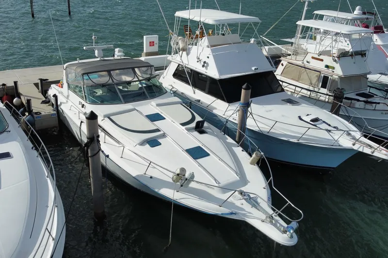 Slide: The Image of 1990 Sea Ray 420 Sundancer docked among other boats in a marina. - 4
