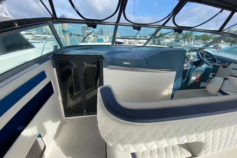 Slide: The Image of 1990 Sea Ray 420 Sundancer cockpit with blue and white seating, marina view. - 40