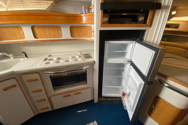 Slide: The Image of Interior of 1990 Sea Ray 420 Sundancer yacht kitchen with open fridge and stove. - 46