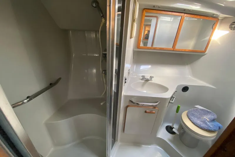 Slide: The Image of 1990 Sea Ray 420 Sundancer bathroom with shower, sink, and toilet. - 47