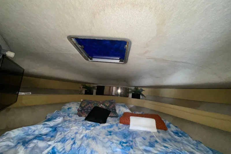 Slide: The Image of Cozy cabin interior of 1990 Sea Ray 420 Sundancer with bed and skylight. - 49