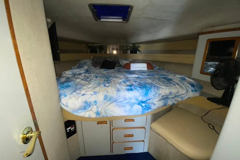 Slide: The Image of Cozy cabin interior of 1990 Sea Ray 420 Sundancer with bed and storage drawers. - 50