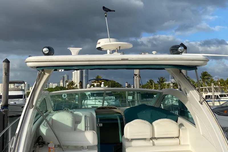 Slide: The Image of 1990 Sea Ray 420 Sundancer yacht docked, with city skyline and cloudy sky in background. - 57