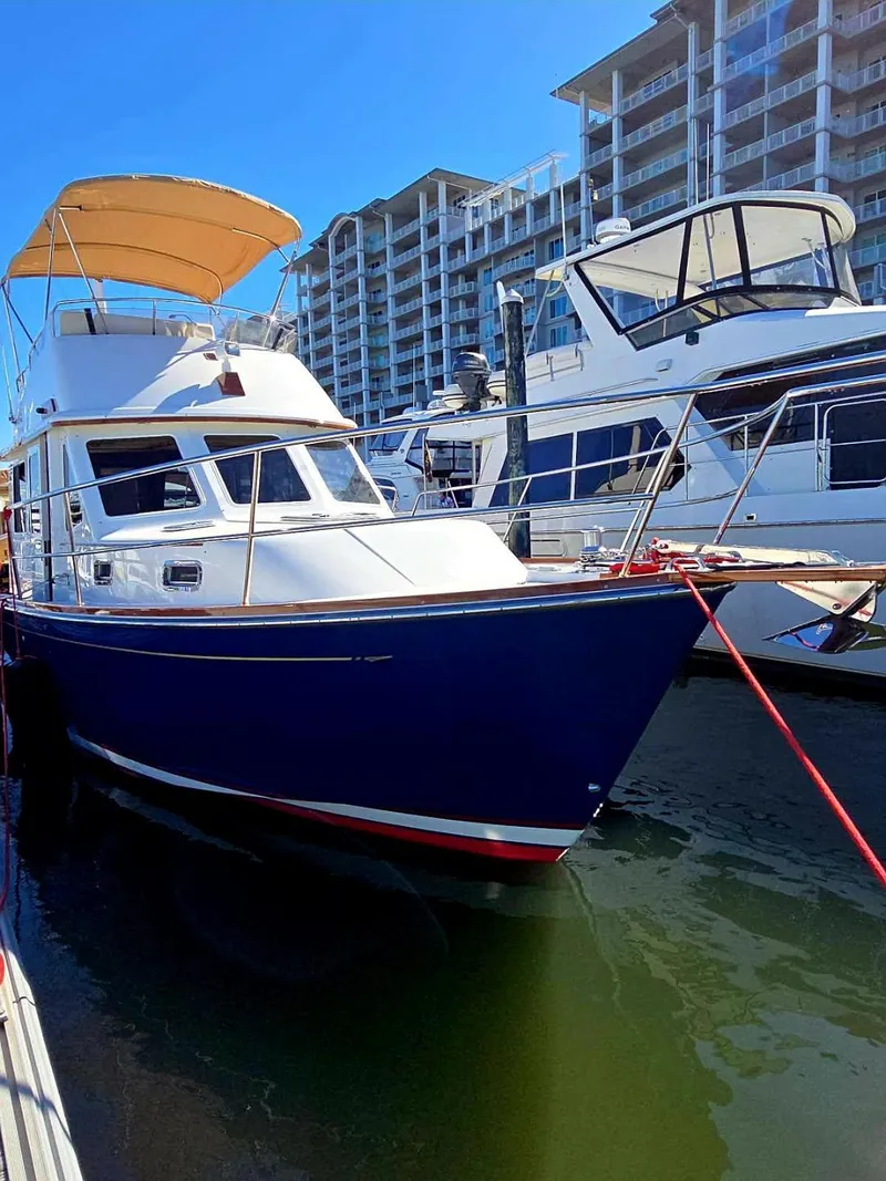 Slide: The Image of 2004 Sabre 36 Flybridge Fast Trawler docked at marina, blue hull, sunny day. - 5