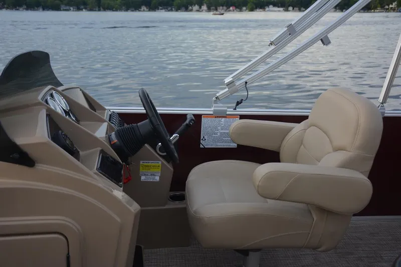 Slide: The Image of 2026 Sylvan Mirage 820 Cruise interior with beige seating and modern helm design. - 3