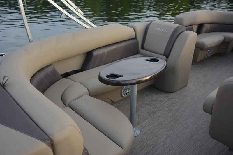 Slide: The Image of 2026 Sylvan Mirage 820 Cruise interior with beige seating and a small round table. - 5