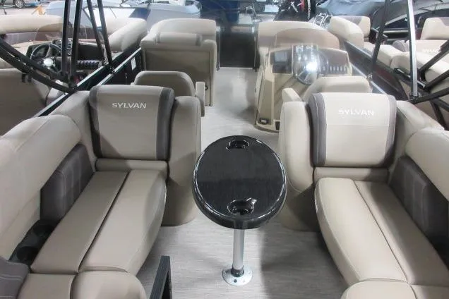 Slide: The Image of 2026 Sylvan Mirage Cruise 822 LZ pontoon boat interior with beige seating and central table. - 12