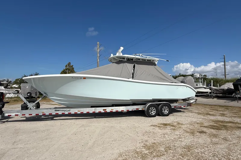 Slide: The Image of 2018 Yellowfin 32 Offshore boat on trailer, covered, under clear blue sky. - 107