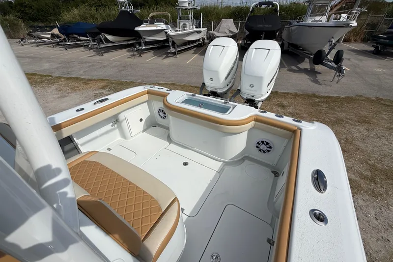 Slide: The Image of 2018 Yellowfin 32 Offshore boat interior with dual engines, parked among other boats. - 11