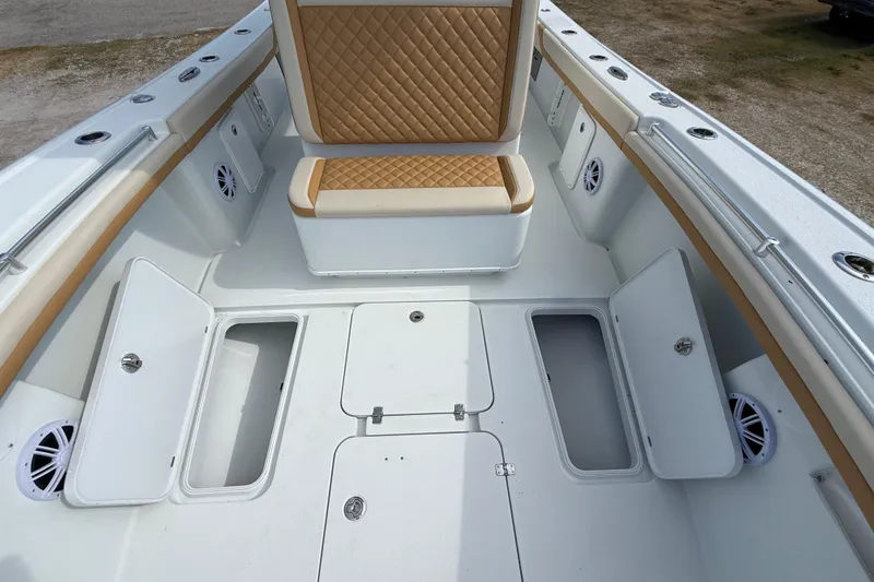 Slide: The Image of 2018 Yellowfin 32 Offshore boat interior with storage compartments and cushioned seating. - 26