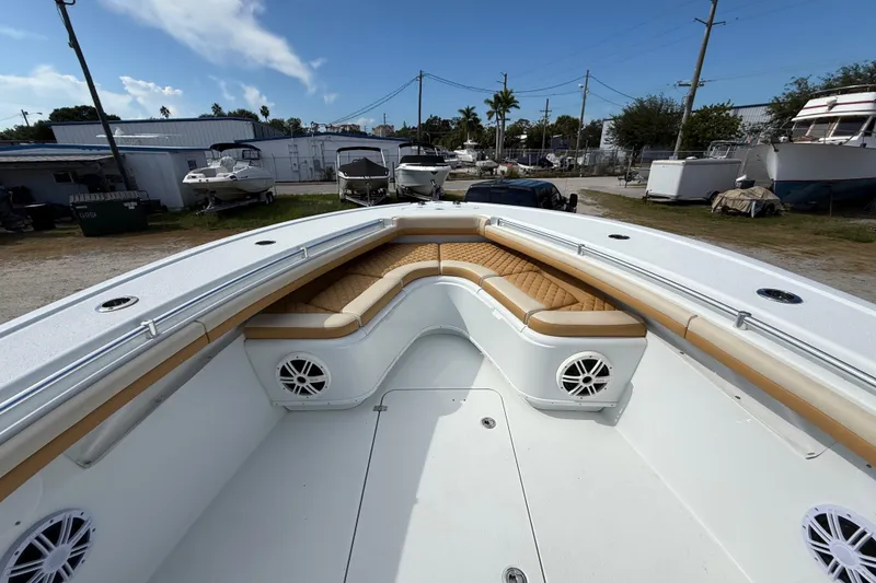 Slide: The Image of 2018 Yellowfin 32 Offshore boat with tan seating and white deck in a marina. - 34
