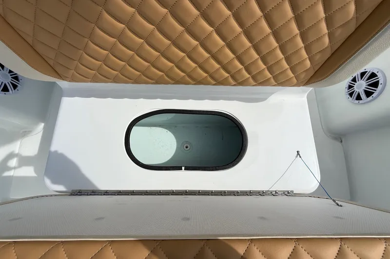 Slide: The Image of 2018 Yellowfin 32 Offshore boat interior with tan quilted seats and oval hatch. - 38