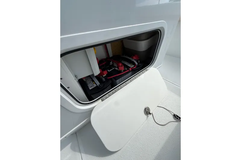 Slide: The Image of Open storage compartment on 2018 Yellowfin 32 Offshore boat, showing equipment and battery. - 46