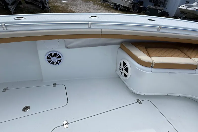 Slide: The Image of 2018 Yellowfin 32 Offshore boat interior with cushioned seating and built-in speakers. - 51