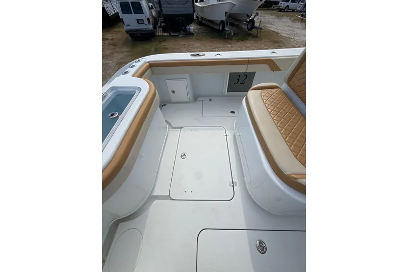 Slide: The Image of 2018 Yellowfin 32 Offshore boat interior with tan seating and storage compartments. - 58