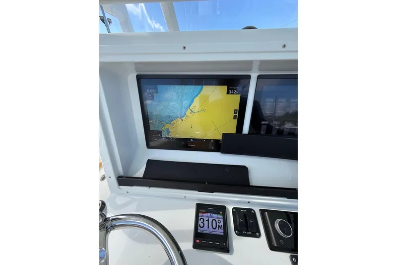 Slide: The Image of 2018 Yellowfin 32 Offshore boat dashboard with navigation display and controls. - 75