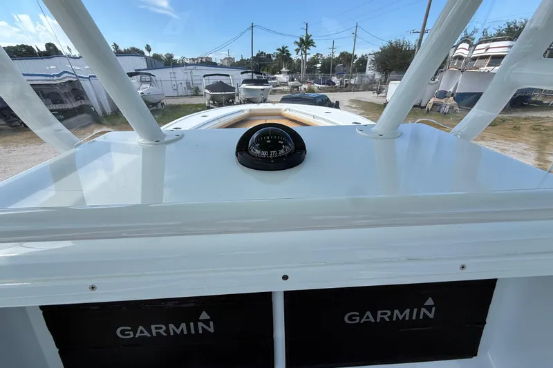 Slide: The Image of 2018 Yellowfin 32 Offshore boat dashboard with compass and Garmin displays. - 81
