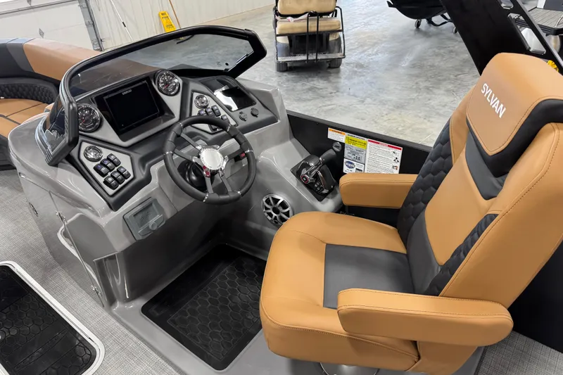 Slide: The Image of 2026 Sylvan L5 DLZ Platinum boat cockpit with tan and black captain's chair. - 13
