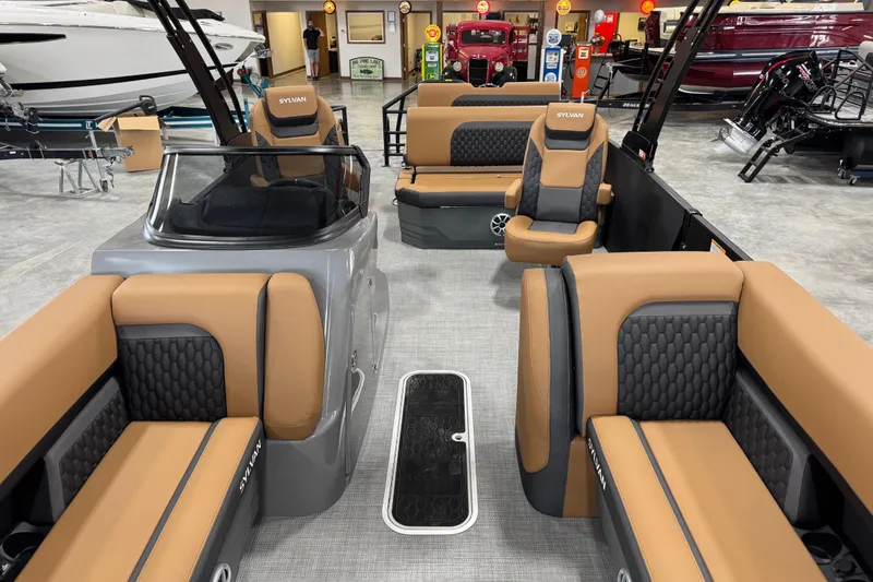Slide: The Image of 2026 Sylvan L5 DLZ Platinum pontoon boat interior with tan and black seating. - 16