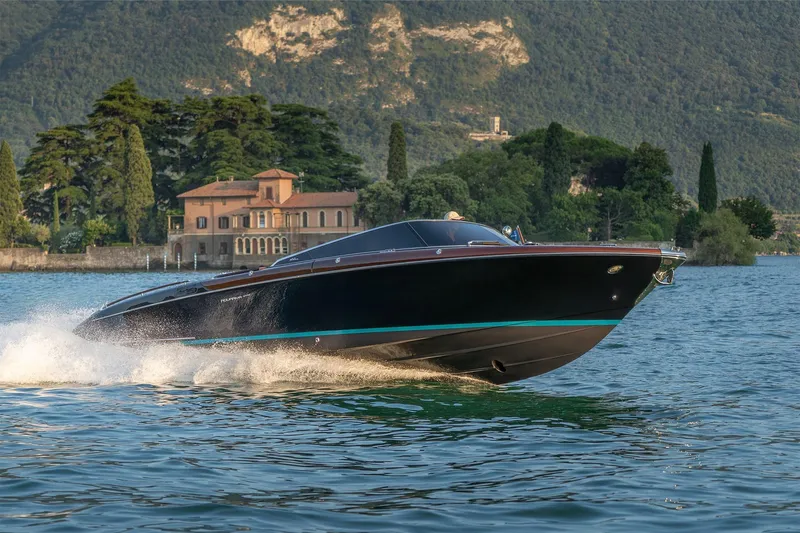The Image of 2026 Riva 33 Aquariva Special cruising on a scenic lake with a villa backdrop. - 0